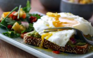 a healthy breakfast of eggs, vegetables, and avocado