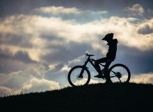 A rider sitting on a mountain bike watching the sunset