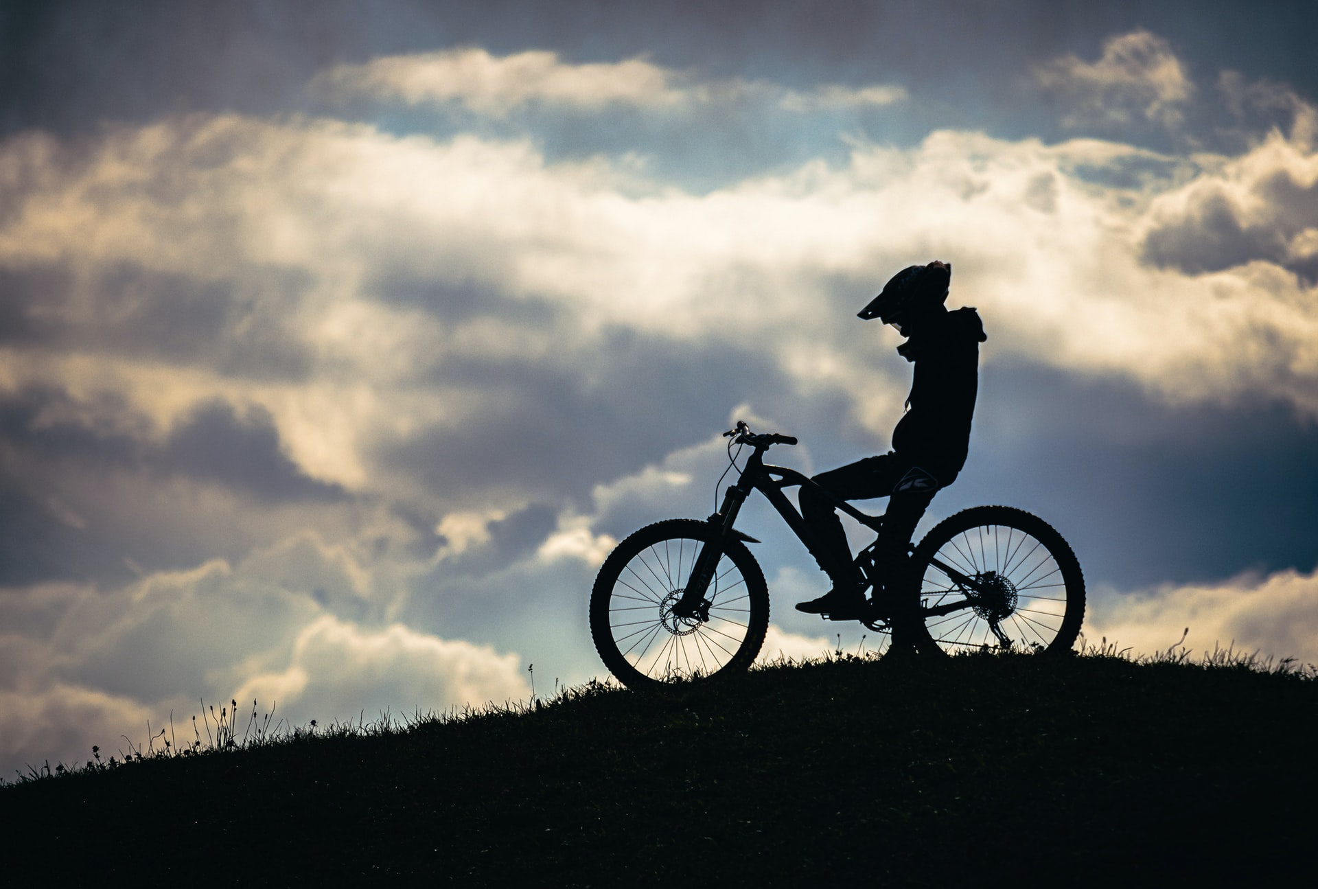 A rider sitting on a mountain bike watching the sunset